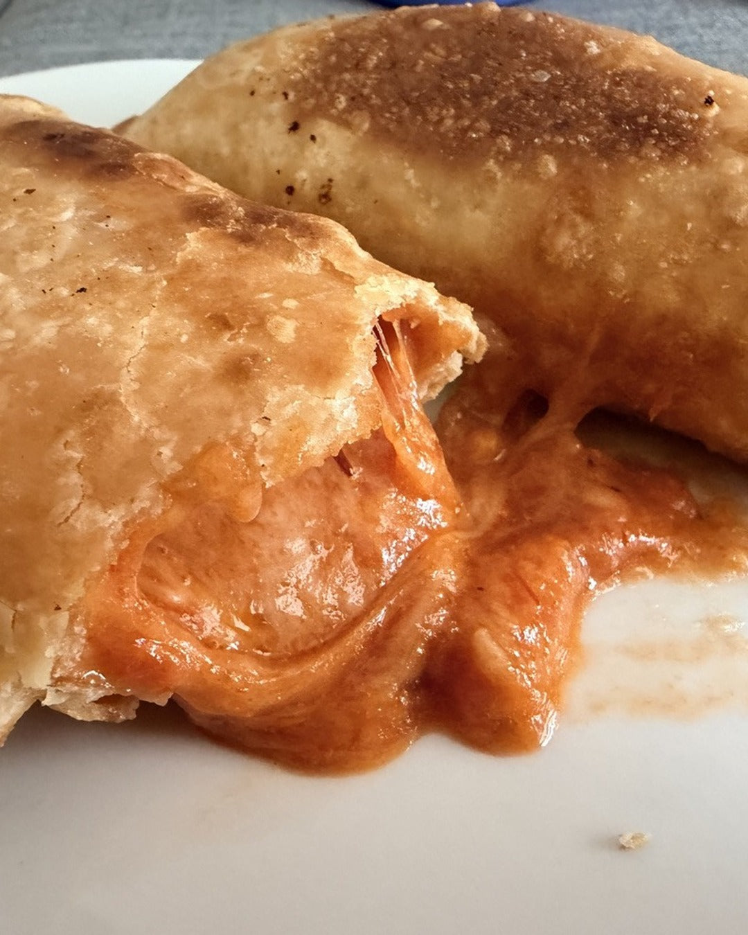 Empanada de pizza con queso cheddar derretido - Hoot & Bake