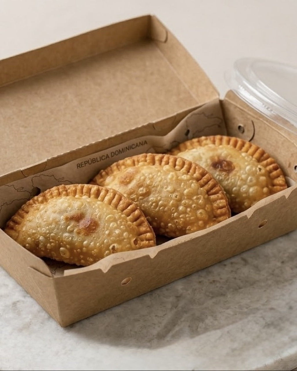 Trío de empanadas Hoot & Bake en caja de delivery